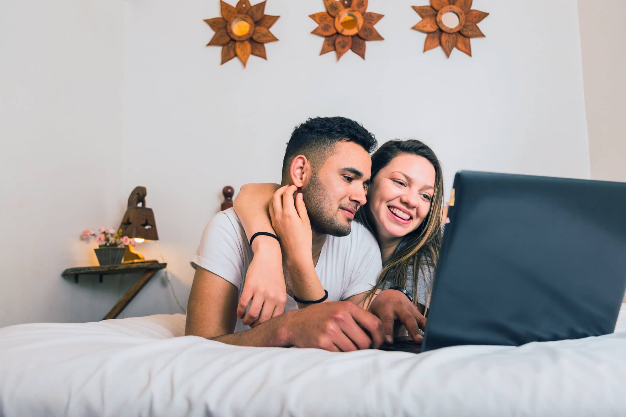 young-couple-bed-look-laptop-concept-technology-communication-love-min-1